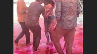 Group of men fondle an Indian girl's breasts during Holi celebration